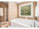 Bright bathroom featuring a soaking tub with a window, and a glass shower stall at 1156 Magnolia Dr, Villa Rica, GA 30180