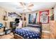 Bedroom with wooden floors, ceiling fan, guitars, gaming setup, and unique decor at 1156 Magnolia Dr, Villa Rica, GA 30180