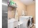 Laundry room equipped with modern washer and dryer, utility sink, and ample storage space at 1156 Magnolia Dr, Villa Rica, GA 30180