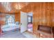 Bright bedroom with wooden plank walls, a colorful bed, and a window with floral curtains at 2669 Jefferson Terrace Ter, East Point, GA 30344