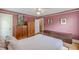 Bedroom boasts hardwood floors, baseboard trim, dresser, armoire, and natural light at 2669 Jefferson Terrace Ter, East Point, GA 30344