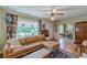 Bright living room with hardwood floors, leather sofa, and large windows with floral curtains at 2669 Jefferson Terrace Ter, East Point, GA 30344