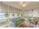 The sunroom features a blue love seat, tropical decor, and natural light at 2669 Jefferson Terrace Ter, East Point, GA 30344