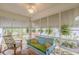 The sunroom features a blue love seat, tropical decor, and natural light at 2669 Jefferson Terrace Ter, East Point, GA 30344