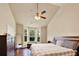 Bedroom with vaulted ceiling, ceiling fan, hardwood floors, large window, and dresser at 2685 Sardis Chase Ct, Buford, GA 30519