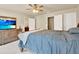 Relaxing bedroom with a large TV on a dresser, ceiling fan, and easy access to bathroom and closet at 2685 Sardis Chase Ct, Buford, GA 30519