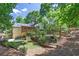 Backyard featuring a screened porch, mature trees, and stone retaining walls at 4655 Latimer Ne Ct, Kennesaw, GA 30144