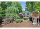 Backyard with play set, lush landscaping, and peaceful surroundings at 4655 Latimer Ne Ct, Kennesaw, GA 30144