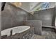 Luxurious bathroom with soaking tub, chandelier, and tiled walls at 4655 Latimer Ne Ct, Kennesaw, GA 30144