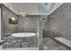 Modern bathroom featuring a soaking tub, pebble tiling, walk-in shower and TV for the ultimate relaxation experience at 4655 Latimer Ne Ct, Kennesaw, GA 30144