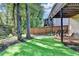 Inviting backyard featuring a well-maintained lawn and a partially covered patio area with natural landscaping at 10000 Barston Ct, Johns Creek, GA 30022