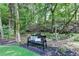 Scenic backyard retreat with a decorative bench, lush greenery, and mulch at 10000 Barston Ct, Johns Creek, GA 30022