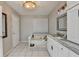 Bathroom featuring marble countertops, custom cabinets, updated fixtures, and a jacuzzi tub at 10000 Barston Ct, Johns Creek, GA 30022