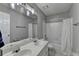 Bright bathroom featuring a double sink vanity and a shower tub with a curtain at 10000 Barston Ct, Johns Creek, GA 30022