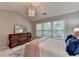 Bright bedroom featuring a decorative chandelier, large dresser, and natural light from the window at 10000 Barston Ct, Johns Creek, GA 30022