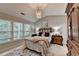 Bedroom featuring ceiling fan, large windows, and comfortable bed with decorative pillows at 10000 Barston Ct, Johns Creek, GA 30022