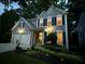 Charming two-story home with a two-car garage, stone bench, and manicured landscaping at 10000 Barston Ct, Johns Creek, GA 30022