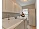 Laundry room with storage cabinets and modern washer and dryer units at 10000 Barston Ct, Johns Creek, GA 30022