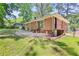 Brick house backyard featuring a patio area, green grass, and mature trees providing ample shade at 2215 Springdale Sw Rd, Atlanta, GA 30315