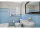 Retro blue-tiled bathroom with a sink, toilet, tub, and window at 2215 Springdale Sw Rd, Atlanta, GA 30315