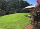 Large backyard featuring green grass, mature trees, and a patio with furniture at 3692 Ramsey Cir, Atlanta, GA 30331