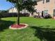 Manicured backyard featuring a dining set, lush lawn, decorative landscaping, and two-story home at 3692 Ramsey Cir, Atlanta, GA 30331