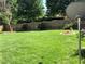 Large grassy backyard featuring a wooden fence, decorative flower beds and mature shade trees at 3692 Ramsey Cir, Atlanta, GA 30331