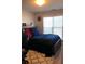 Cozy bedroom featuring a large window with blinds, dark wooden furniture, and soft carpet at 3692 Ramsey Cir, Atlanta, GA 30331