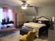 Well-appointed bedroom with furniture, a ceiling fan, and a window with pink curtains at 3692 Ramsey Cir, Atlanta, GA 30331