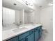 Bathroom with a blue vanity, white countertop, dual sinks, and a large mirror at 420 Berckman Nw Dr, Lilburn, GA 30047