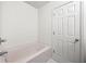 Cozy bathroom showcasing a bathtub, clean white walls, and a classic white door at 420 Berckman Nw Dr, Lilburn, GA 30047