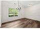 Light filled dining room with stylish light fixture and new wood flooring at 420 Berckman Nw Dr, Lilburn, GA 30047
