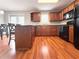 Well-equipped kitchen featuring wood cabinetry, island and black appliances with dining area at 602 Summer Pl, Norcross, GA 30071