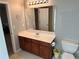 Well-lit bathroom features a single sink vanity, large mirror, and convenient toilet placement at 929 Wexford Way, Auburn, GA 30011