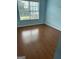 Bedroom featuring wood-look flooring, pale blue walls, and a window providing natural light at 929 Wexford Way, Auburn, GA 30011