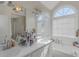 Bright bathroom with dual sinks, a large mirror, and a soaking tub near a window at 147 Midland Dr, Stockbridge, GA 30281