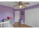 A bedroom with purple walls, a crib, and a closet at 147 Midland Dr, Stockbridge, GA 30281