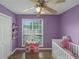 A bedroom with a crib, play kitchen, and purple walls at 147 Midland Dr, Stockbridge, GA 30281