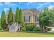 Charming two-story home with a landscaped front yard and symmetrical evergreen trees lining the front entrance at 147 Midland Dr, Stockbridge, GA 30281
