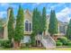 Charming two-story home with a landscaped front yard and symmetrical evergreen trees lining the entrance at 147 Midland Dr, Stockbridge, GA 30281