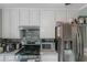 A well-lit kitchen featuring stainless steel appliances, a decorative backsplash, and white cabinets at 147 Midland Dr, Stockbridge, GA 30281