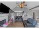 Bright open-concept living room with vaulted ceiling, fireplace, wood-look flooring, and ceiling fan at 147 Midland Dr, Stockbridge, GA 30281