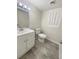 Bathroom features white vanity with sink, toilet, gray floors, and window at 1710 Fontaine Dr, Jonesboro, GA 30236