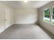 Well-lit bedroom featuring neutral paint, a large window providing natural light, and new carpet at 1710 Fontaine Dr, Jonesboro, GA 30236