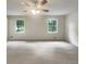 Bright bedroom featuring neutral paint, two windows providing natural light, and new carpet and ceiling fan at 1710 Fontaine Dr, Jonesboro, GA 30236