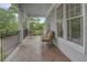 Inviting covered balcony featuring stylish herringbone floors and comfortable seating area at 1764 Defoor Nw Ave, Atlanta, GA 30318