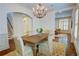 Formal dining room features a modern chandelier, hardwood floors, and an archway into the living area at 1764 Defoor Nw Ave, Atlanta, GA 30318