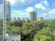 A daytime view of the city from a high rise with lush greenery below and pool in the foreground at 2870 Pharr Court South Nw # 1405, Atlanta, GA 30305