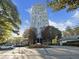 High-rise apartment building featuring manicured landscaping, brick-paved driveway, and tree-lined entrance at 2870 Pharr Court South Nw # 1405, Atlanta, GA 30305