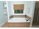 Relaxing bathroom with a large soaking tub, neutral tiling, and natural light from a window at 550 Quillian Ave, Decatur, GA 30032